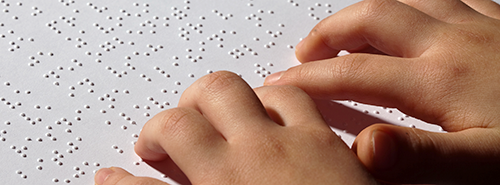 Child's hands reading braille